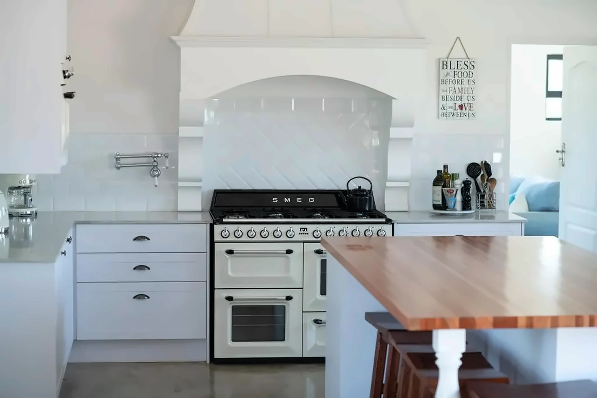 White shaker kitchen with canopy, range cooker and butcher-block island