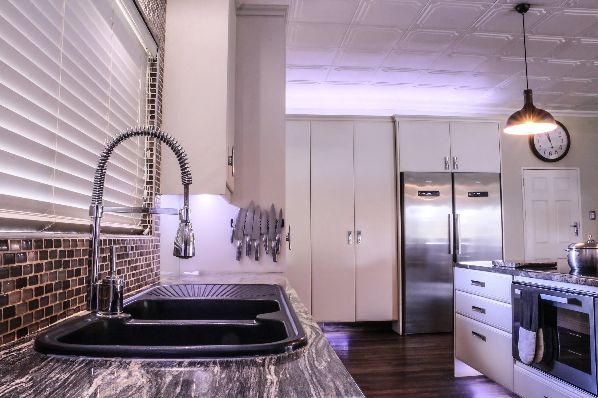 Double sink with pull-down mixer, tall pantry units and stainless fridge