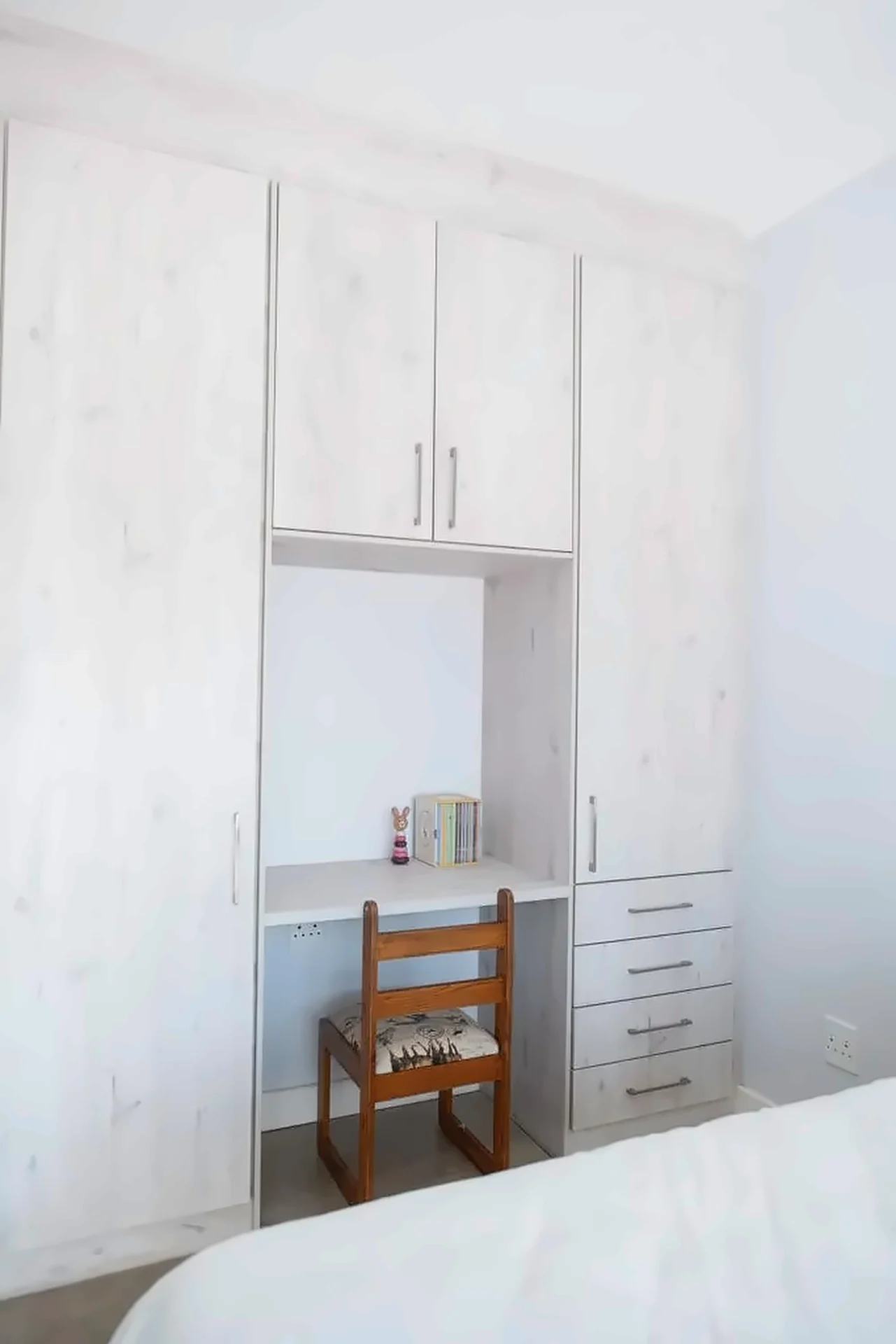 Light timber-finish wardrobe wall with an integrated study desk