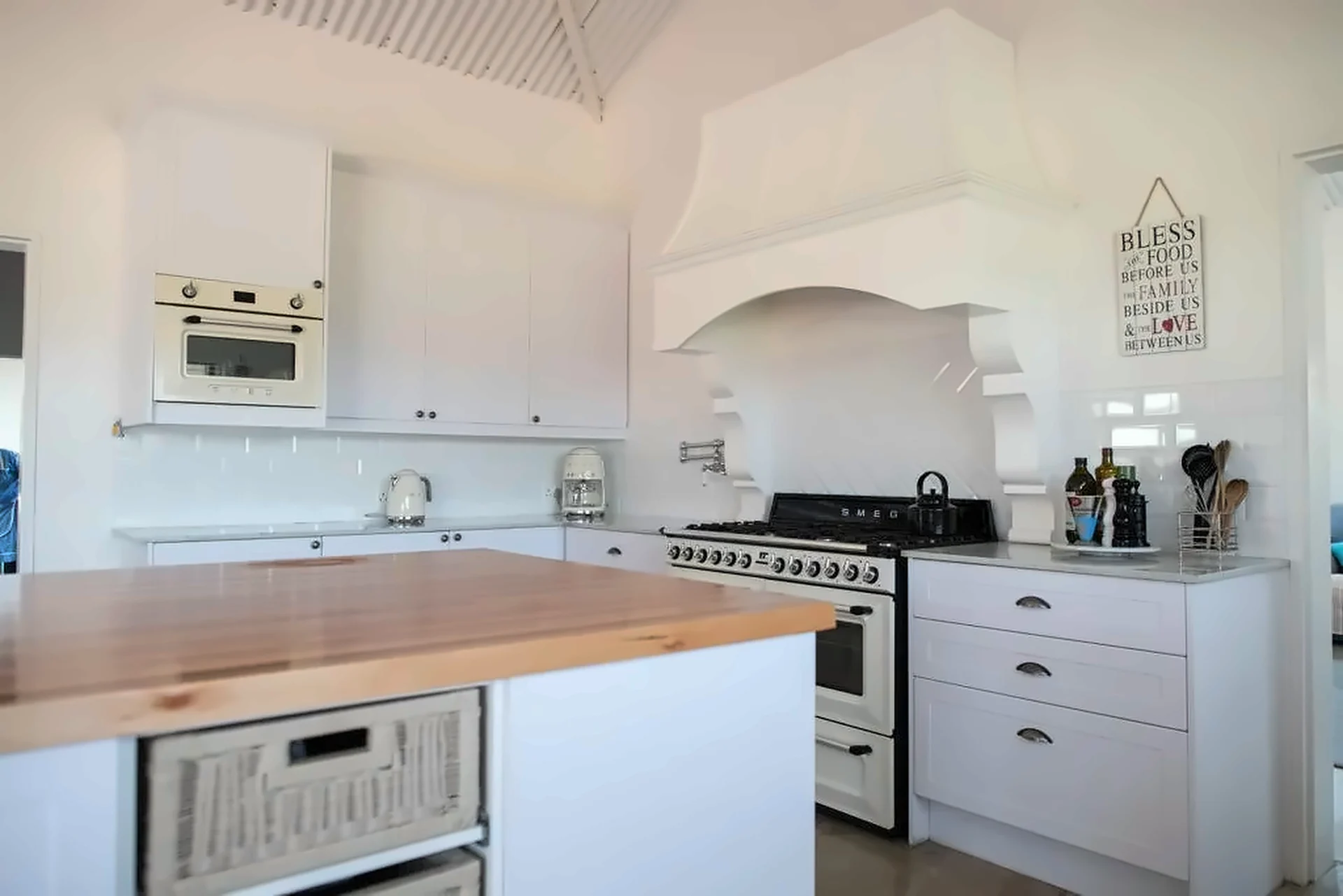 Butcher-block island with wicker basket storage in a white kitchen