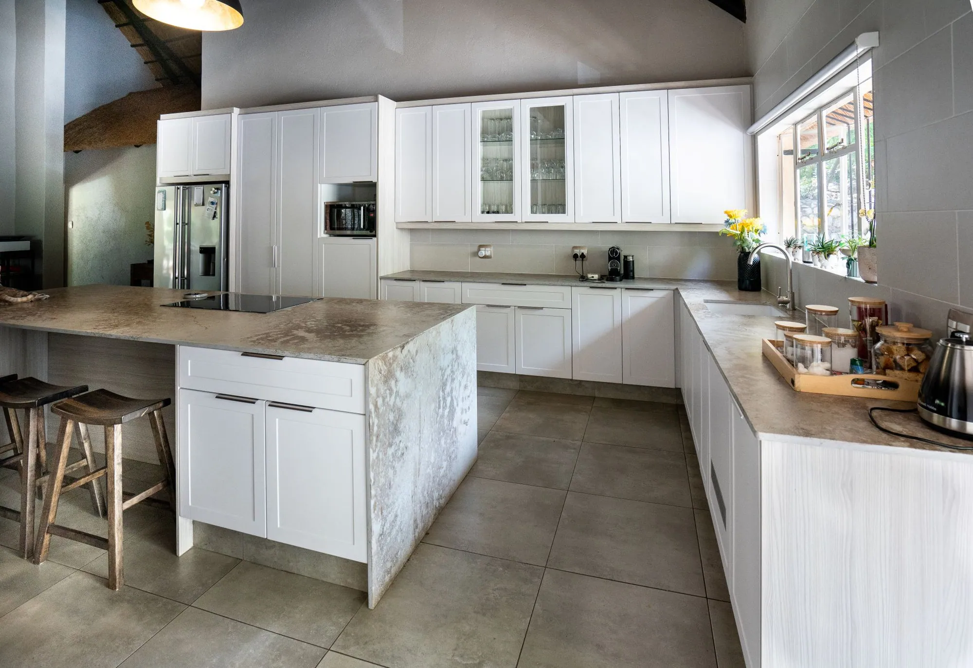 Completed white kitchen with stone-topped island