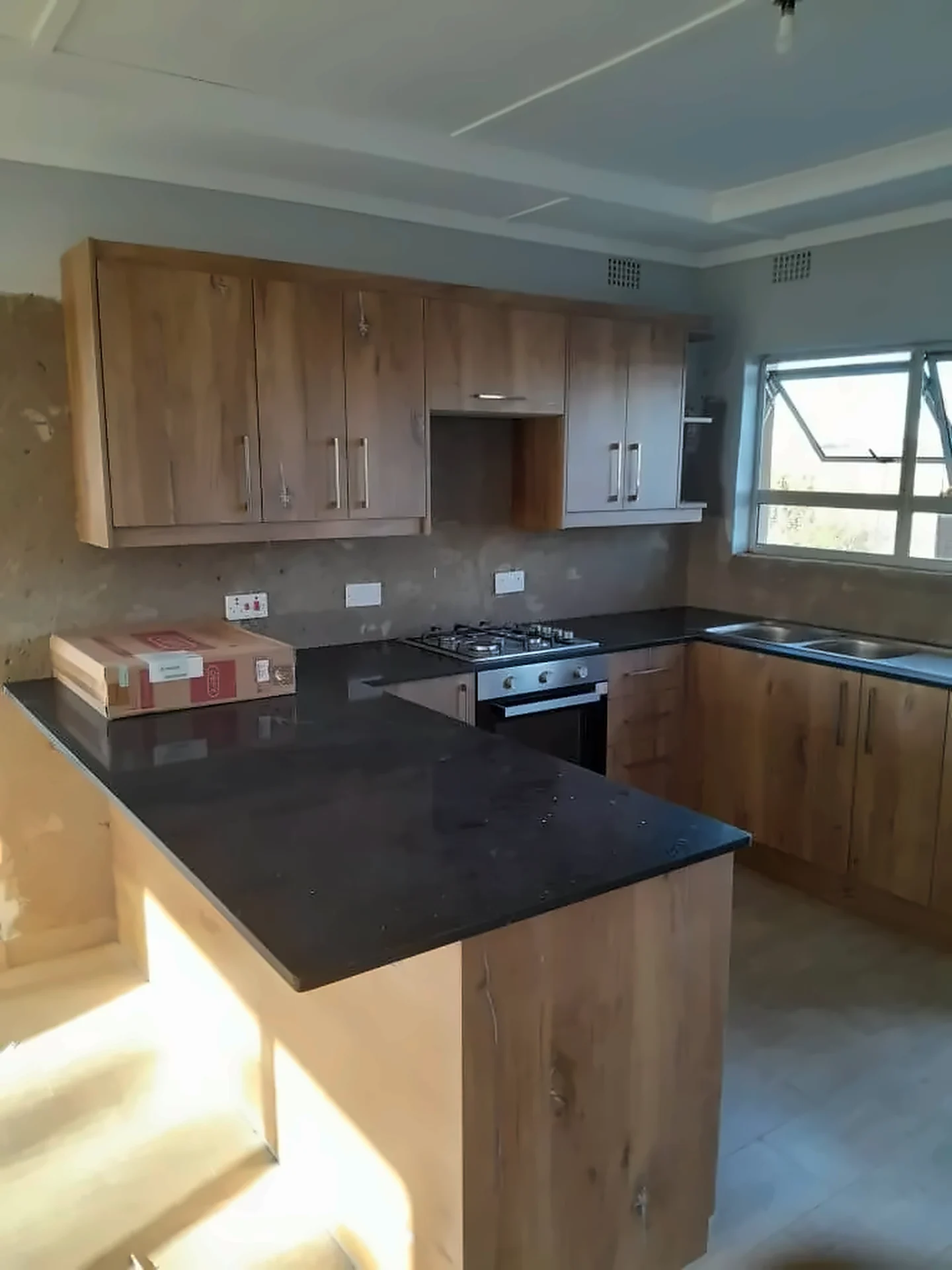 Timber-finish cabinetry with dark granite worktops