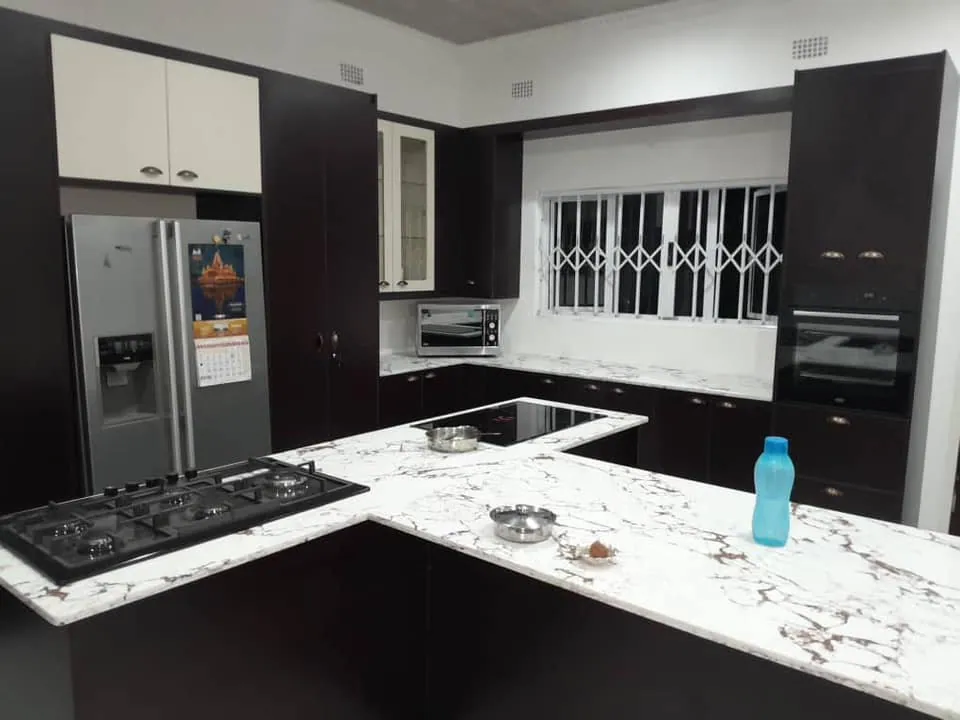 Dark cabinetry with white veined worktops