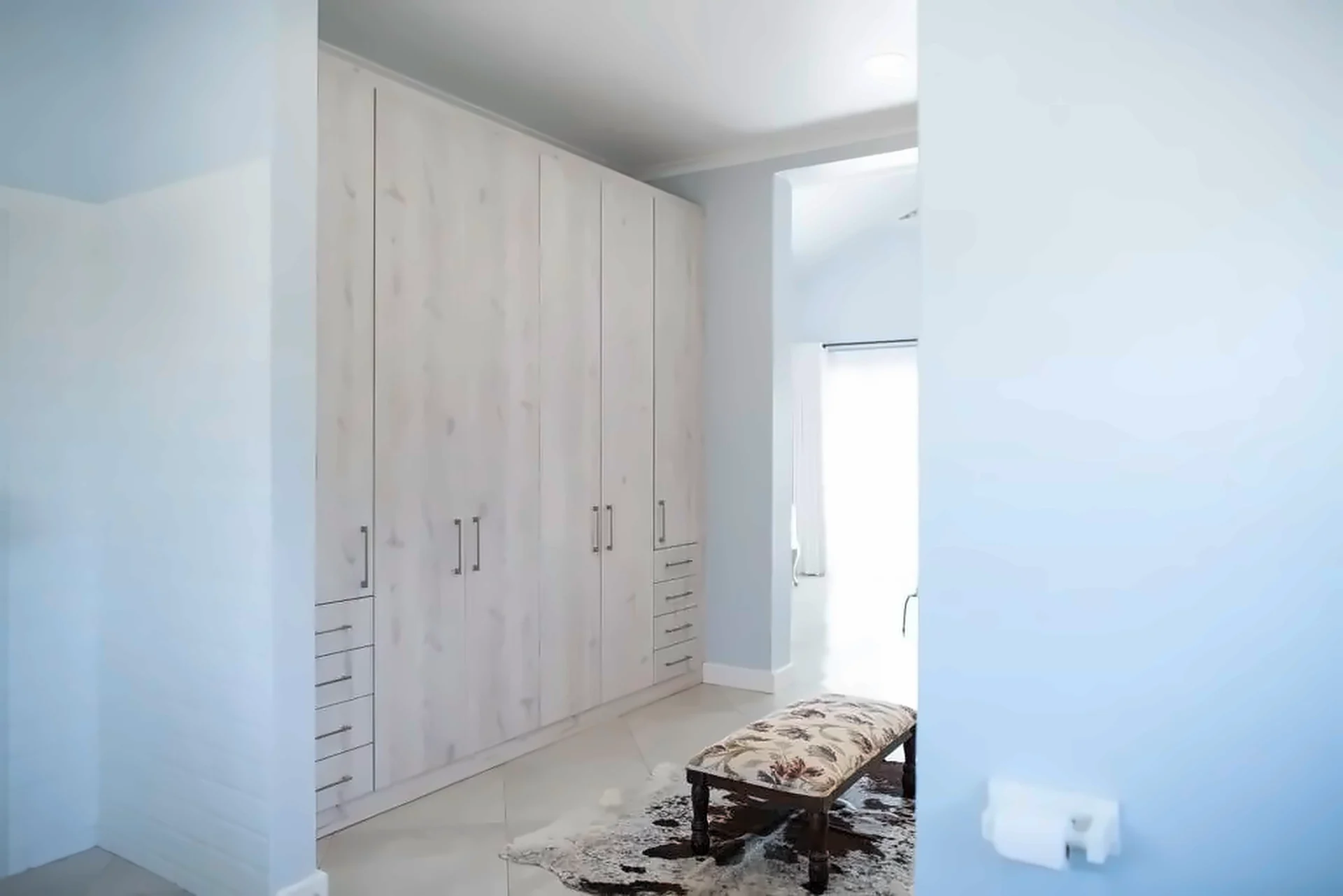 Floor-to-ceiling wardrobe wall in a weathered timber finish