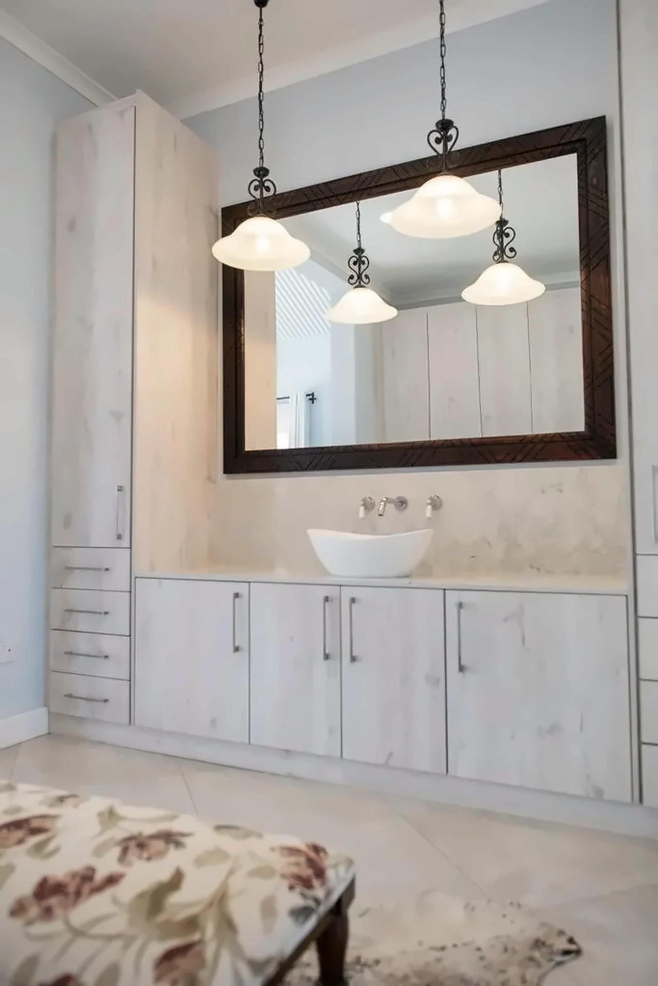 Vanity wall with framed mirror and pendant lights above a vessel basin