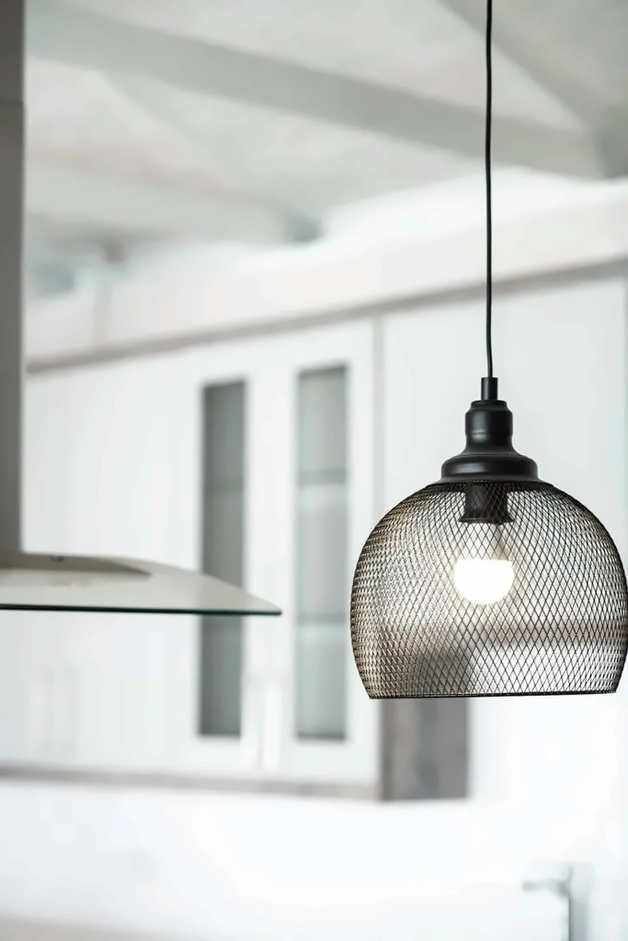 Open-plan kitchen under white trusses: Pendant lighting