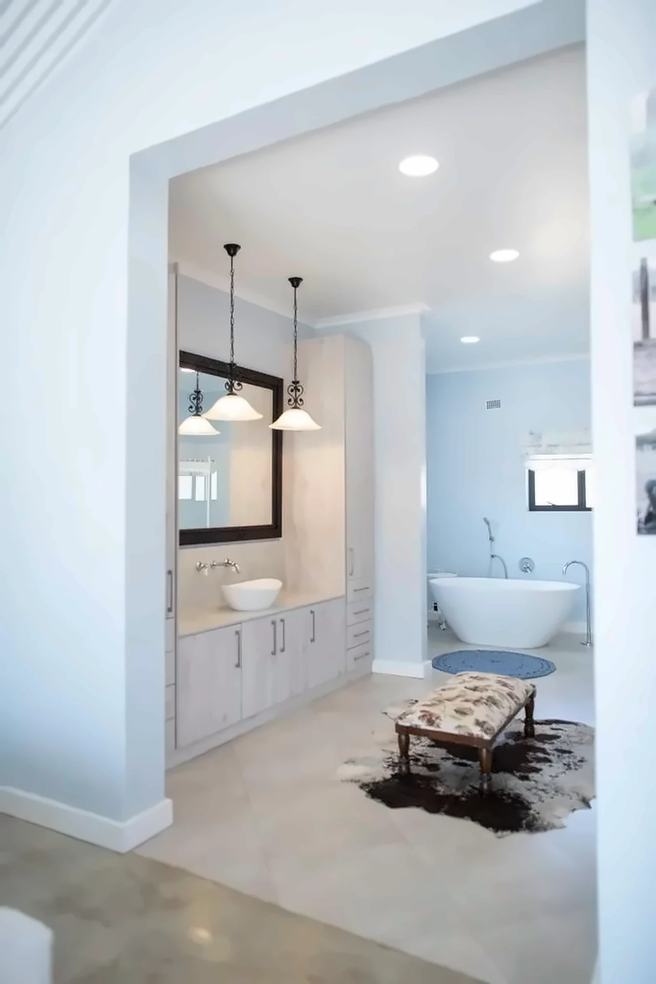 Light timber-finish vanity unit with vessel basin and dark framed mirror