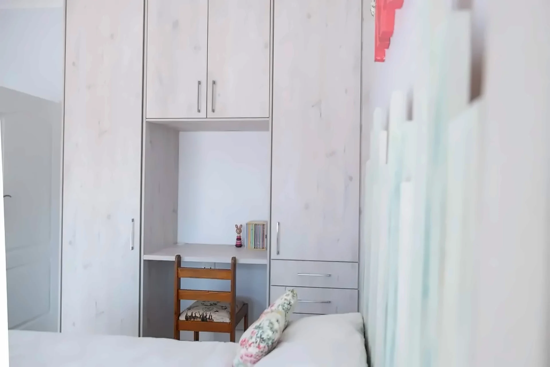 Wardrobe wall with built-in desk niche and drawers in a bedroom